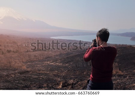 Photographer men standing outdoor photography amidst the beautiful nature of Mt. Fuji at Yamanashi in Japan. Travel and Attractions Concept.