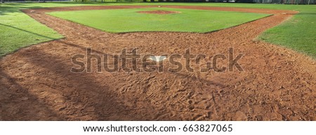 A youth baseball field viewed from behind home plate in morning light Royalty-Free Stock Photo #663827065