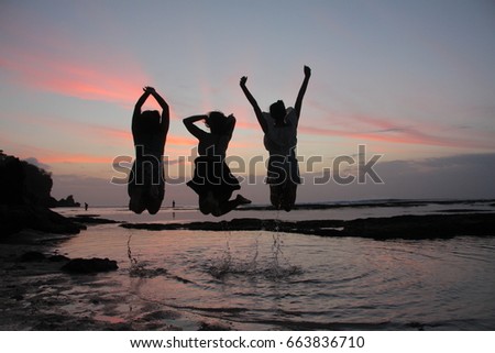 Girls, friends, jumping in the sunset and having fun.