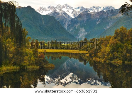Lake Matheson walking track, reflection of the mountains in pristine clear water lake near Fox Glacier in New Zealand's West Coast, South Island