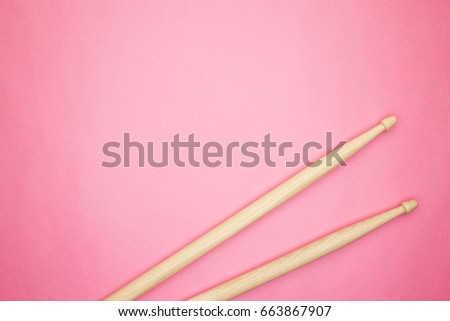pair of wooden drumsticks on pink background
