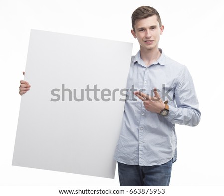 Young happy man portrait of a confident businessman showing presentation, pointing paper placard gray background. Ideal for banners, registration forms, presentation, landings, presenting concept.