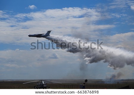 A military plane extinguishes a fire on the field (blurred photo) 