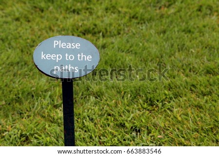 Sign in a grass lawn saying "Please keep to the paths"