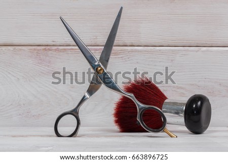 Hairdressing scissors and red brush on the white wooden table