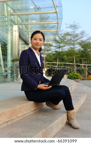 beautiful asian businesswoman working on her laptop outdoor