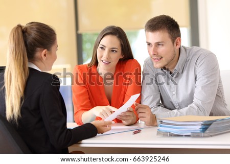 Two happy customers solving doubts about a contract with the saleswoman at office Royalty-Free Stock Photo #663925246