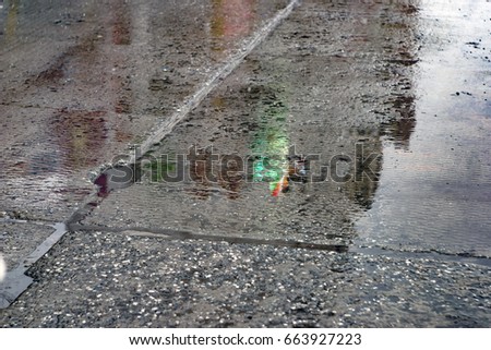 Wet asphalt, reflection of lanterns, traffic lights in a puddle.
