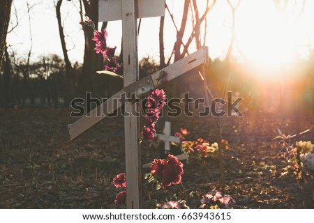 Crosses on the graves of the old cemetery silhouette in the rays of the evening sun