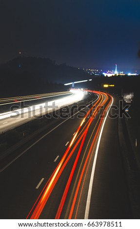 Motion blurred light tracks glowing to the darkness of highway traffic. Long time exposure photography.