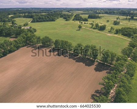 drone image. aerial view of rural area with freshly cultivated fields. green and brown. summer - vintage effect