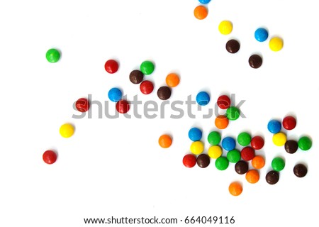 A scattering of colored small chocolates on a white background.
Small colored candies