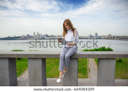 the girl is writing a message on the phone while sitting on the metropolis