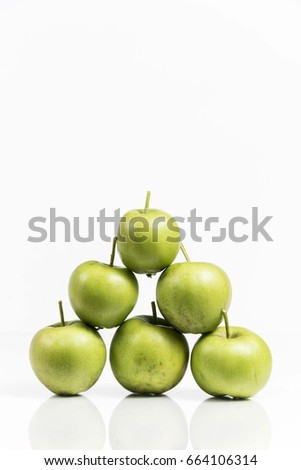 green apples in pyramid shape isolated on white studio background