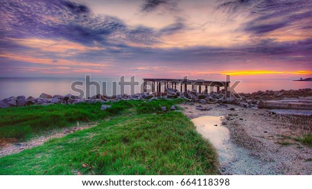 Sunset at Sungai Burung, Selangor, Malaysia during a low tide sea water level. Image has grain or blurry or noise and soft focus when view at full resolution (Shallow DOF, slightly motion blur).