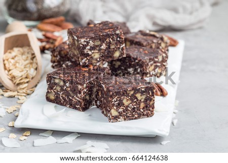 Paleo chocolate energy bars with rolled oats, pecan nuts, dates, chia seeds and coconut flakes, horizontal, copy space Royalty-Free Stock Photo #664124638