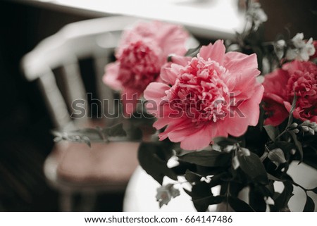 Pink peony in white vase on table