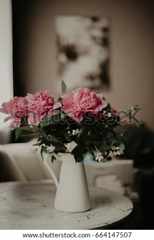 Pink peony in white vase on table