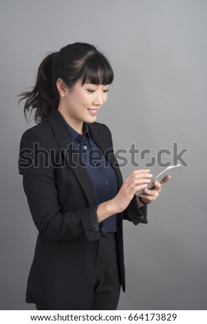 Beautiful business Woman using smartphone on grey background