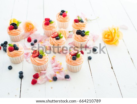 Strawberry cupcakes at wood background. Selective focus. Roses.