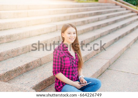  cute girl in the city with phone in hands