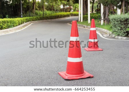 Traffic cone on the asphalt road, used for road safety.