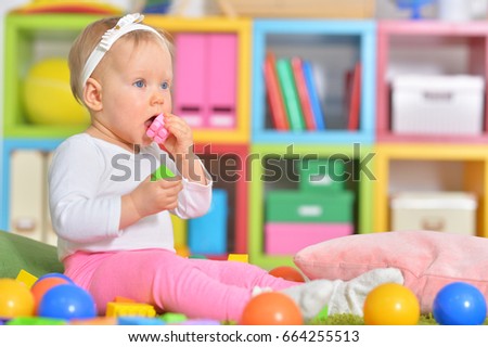 Little child playing with colorful toys 
