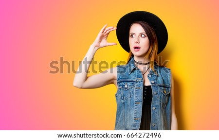 Young girl shocked for something on yellow overflow background