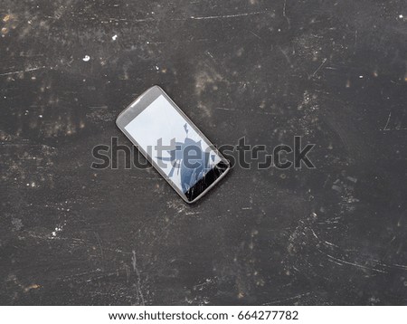 Modern broken mobile phone on black background