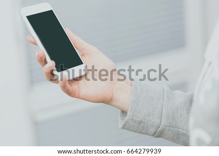 Photography of hands holding smartphone. The concept of the life of a young woman today. Filtered color.