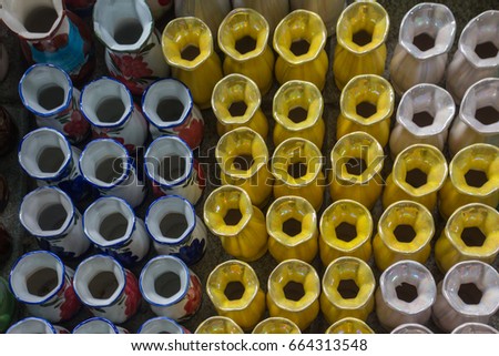 Many yellow vases are viewed from above.