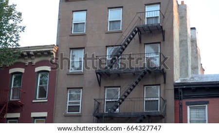 Typical Brooklyn New York City style apartment building exterior establishing shot outside fire escape facade. day time DX evening sunset time photo