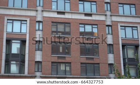 Exterior establishing photo shot of brick luxury office apartment building in city setting. New York City Brooklyn typical style
