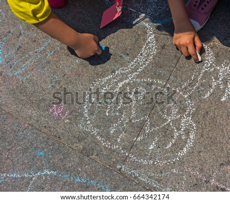 pieces of color chalk on the street floor with drawing on floor.