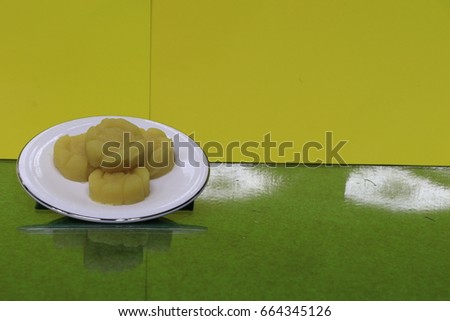 reflection the thai mung bean cookies on white dish on green ground and yellow background