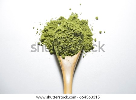 Organic Matcha Green Tea Powder full in spoon and spreads on the white background