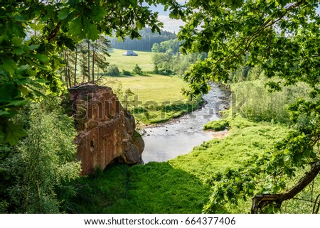 beautyful morning light over forest river of Amata, Cesis, Latvia. sandstone cliffs and green vegetation around water in summer