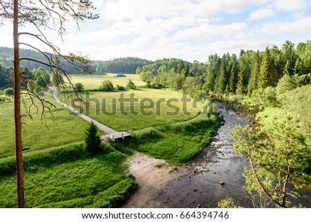 beautyful morning light over forest river of Amata, Cesis, Latvia. sandstone cliffs and green vegetation around water in summer