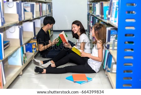 Young students asian together group teenager smile with school folders reading book at library university campus college knowledge center for study learning and bright idea in summer holiday.