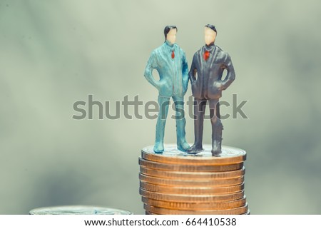 Miniature people, small figures businessmen stand on top of coins. Money and Financial, Business Growth concept. shallow focus in soft tone.