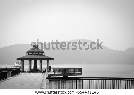 pier and waterfront pavilion, photo in black and white color style (monochrome), copy space, loneliness concept, sun moon lake, Taiwan