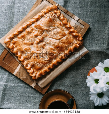 Pie and flowers on wood background