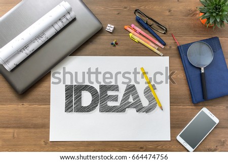 Girl draw text Ideas and get it on paper sheet at the table with a mobile phone, a laptop, business accessories