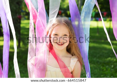 cheerful little girl outdoors , celebrate a birthday. Cheerful children's holiday outdoors. International Children`s Day
