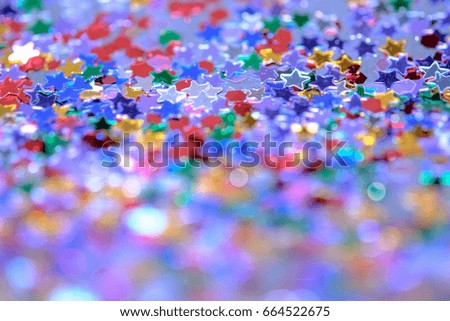 Soft bright and abstract blurred  bokeh background of colourful star confetti.