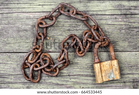 metal chain and locked padlock on wooden background