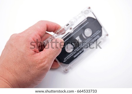 Hand Holding Blurry Cassette Tape Isolated on White Background
