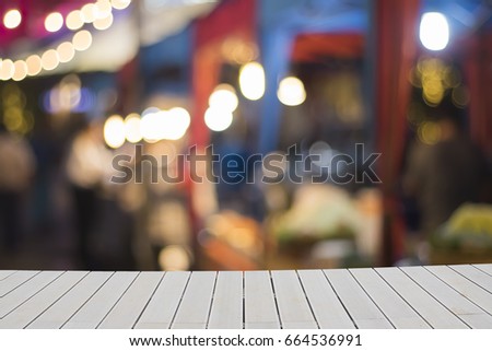 Wooden empty table with blurred background. gray wooden board on blurred on walking street shop. Mock up for text
