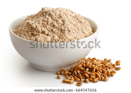 Spelt whole grain flour in white ceramic bowl isolated on white. Spilled winter wheat kernels. Royalty-Free Stock Photo #664547656