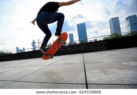 young woman skateboarder skateboarding at city
